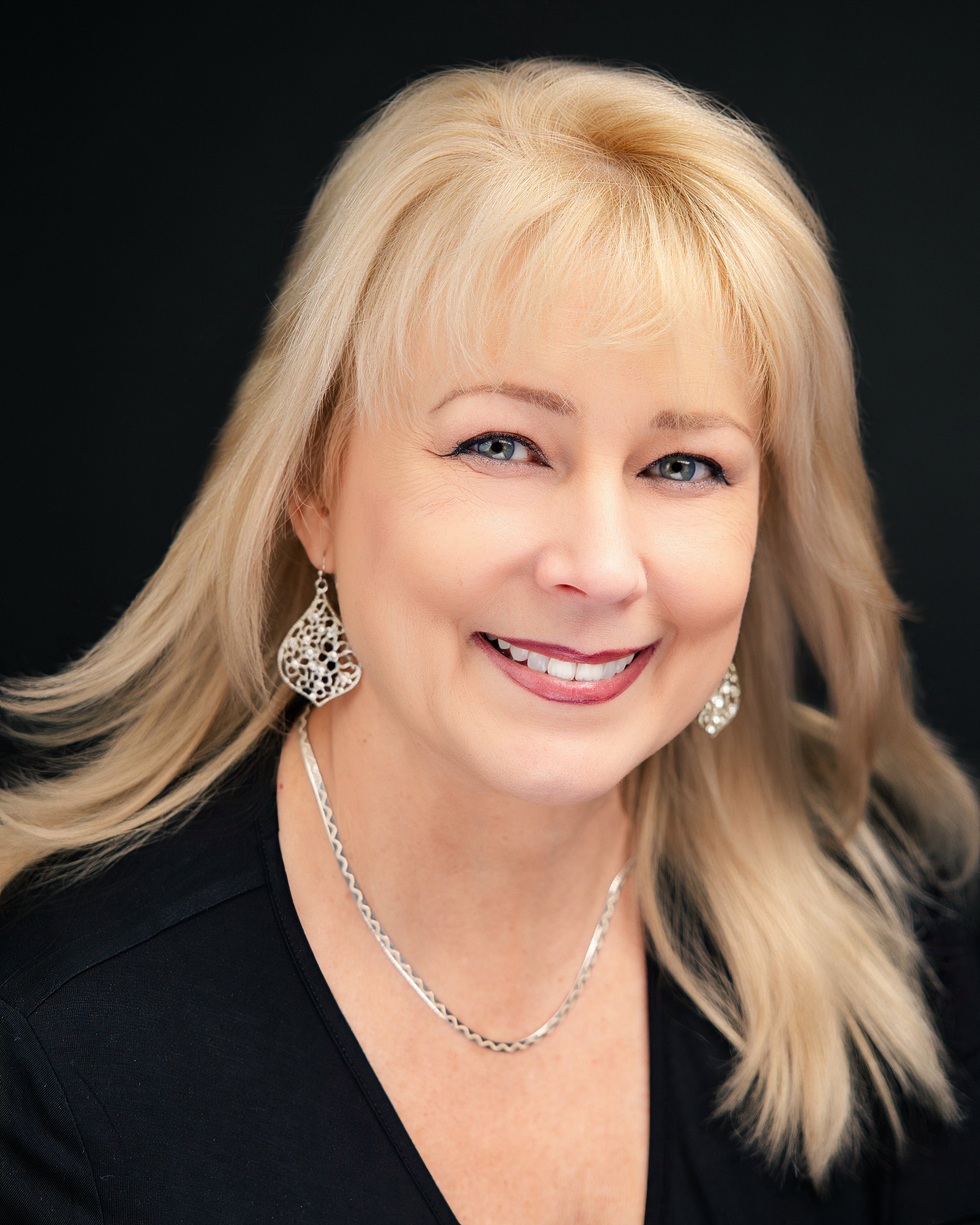 Smiling woman with blonde hair and silver jewelry