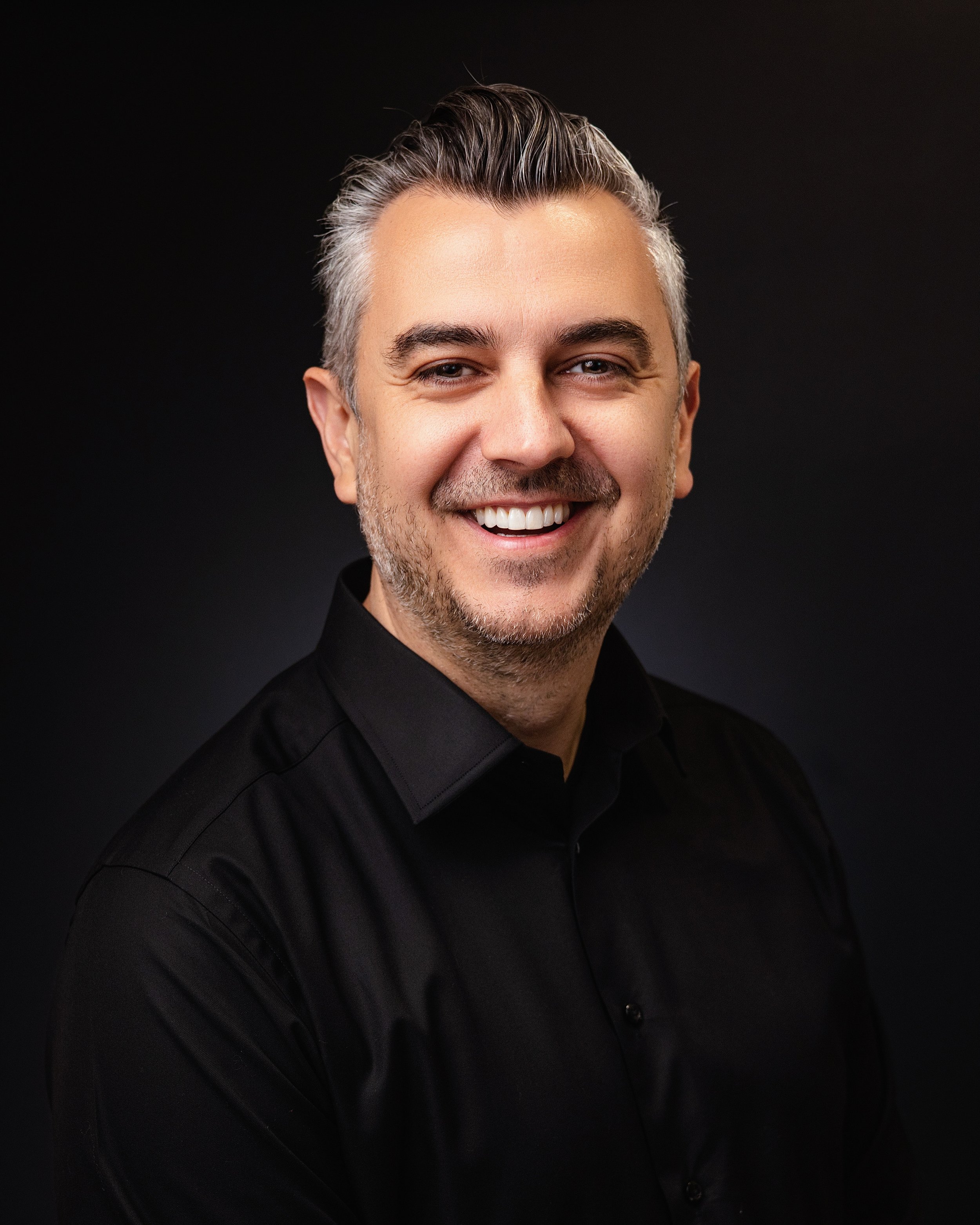 Studio portrait of a man in a black button-up shirt
